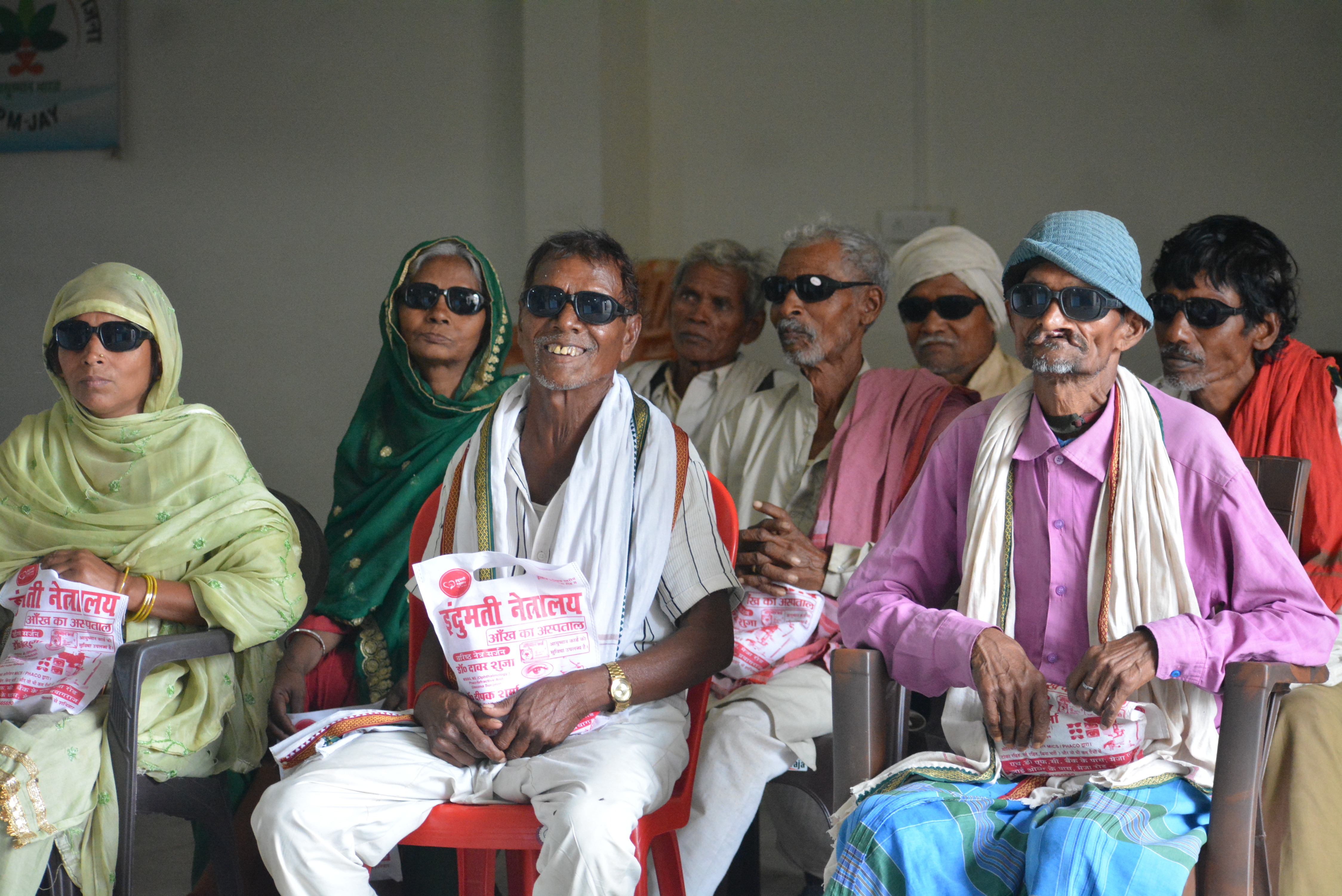 Group of rural patients in recovery with dark glasses after free cataract surgery at Indumati Netralaya eye camp