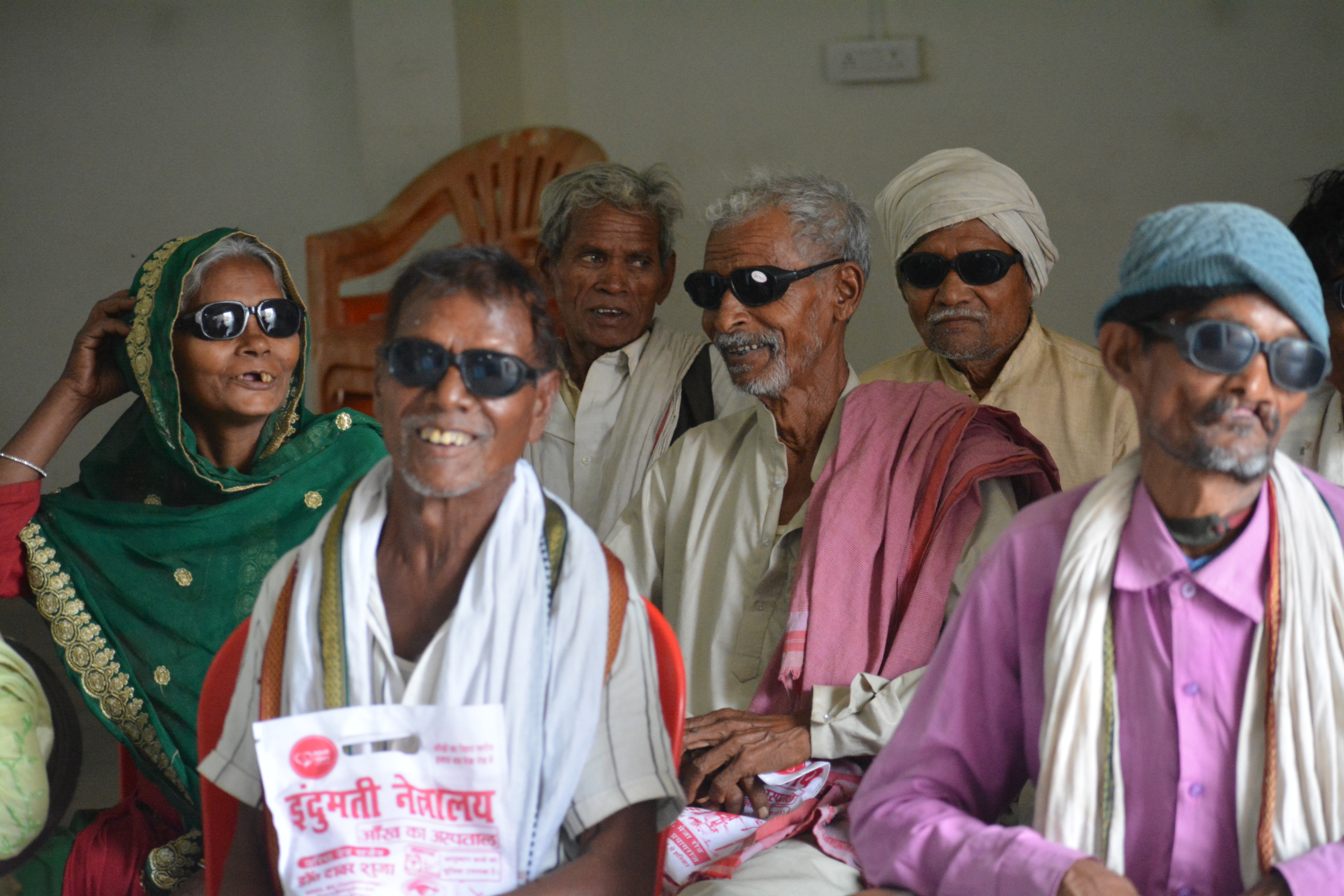 Village patients sitting together after free eye surgery at Indumati Netralaya eye camp, rural UP